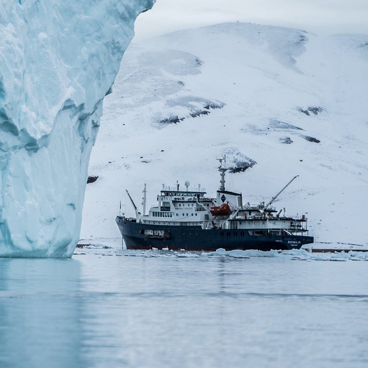 Ein Schiff steht vor einem Gletscher 