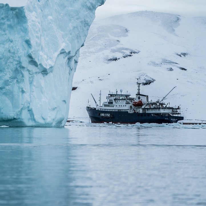 Ein Schiff steht vor einem Gletscher 